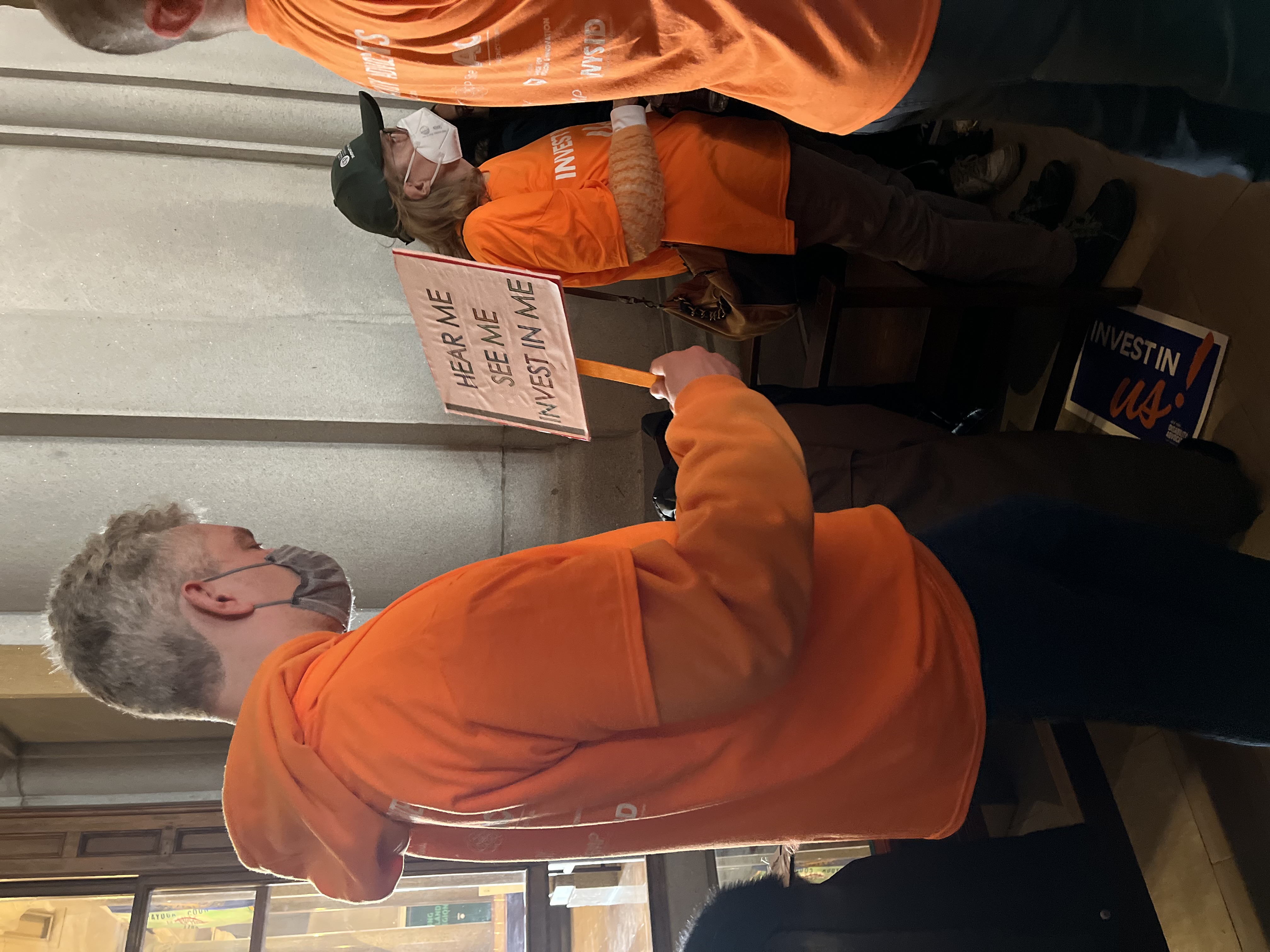 Man holding a hear me, see me, invest in me sign at NYDA Rally