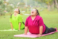 Two young women with developmental disabilities practicing yoga outside