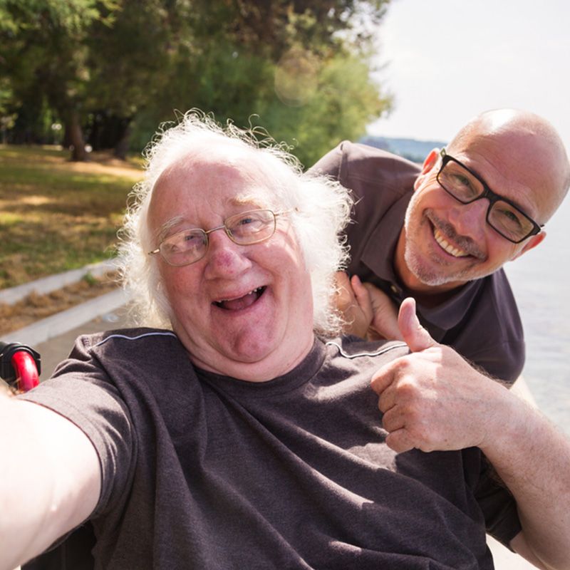 Older man in a wheel chare and his friend