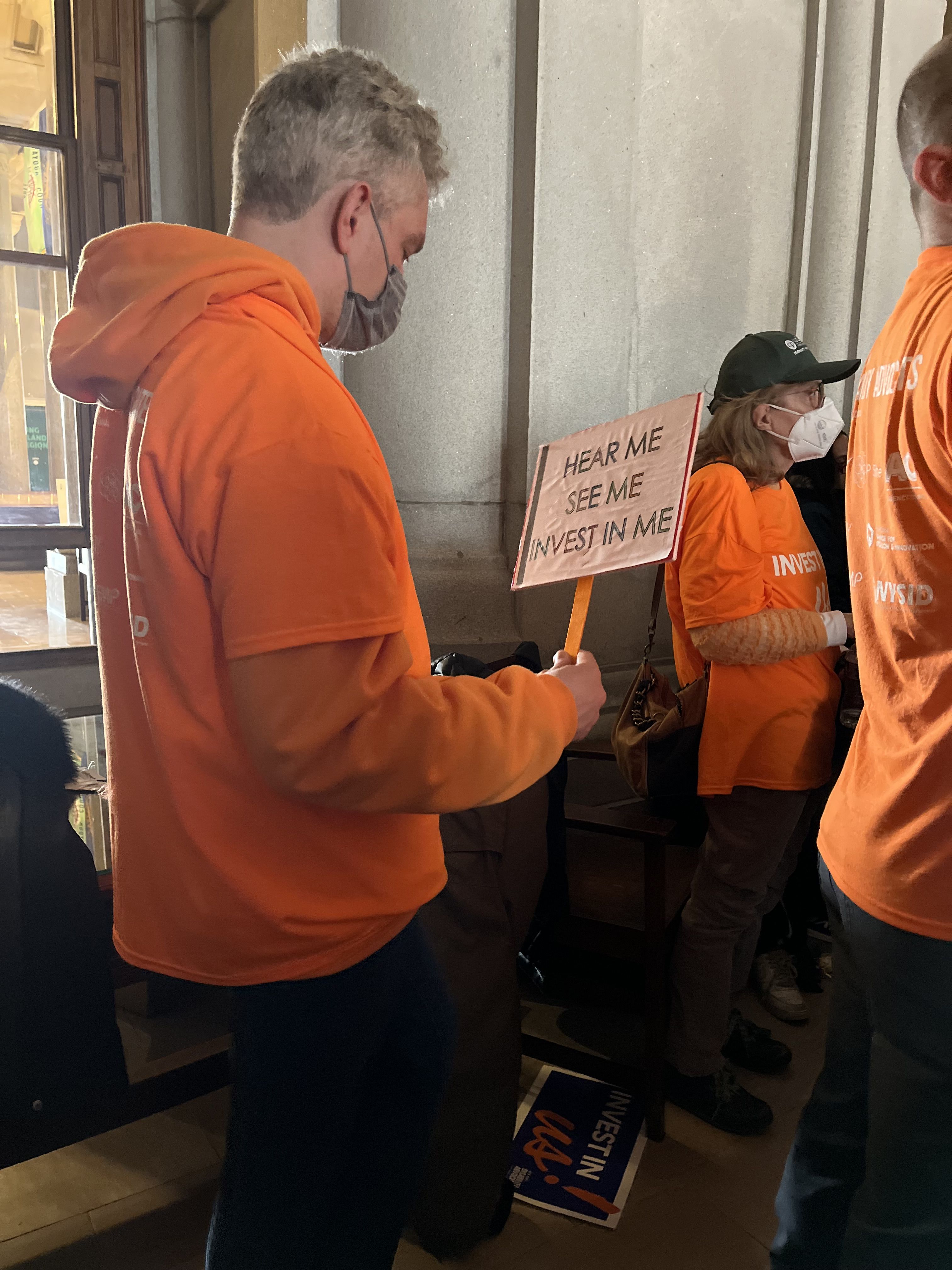 Man holding a hear me, see me, invest in me sign at NYDA Rally